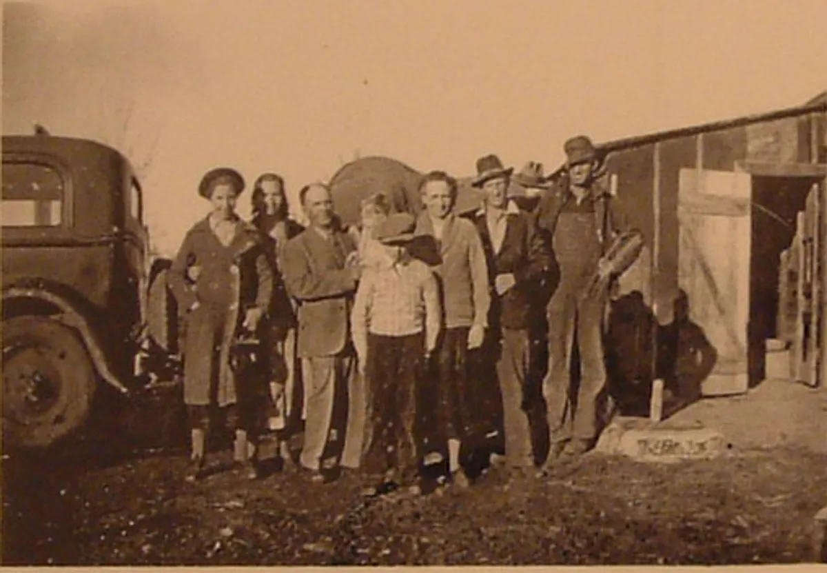 Before: sepia photo of a group of men and women beside an old truck and barn