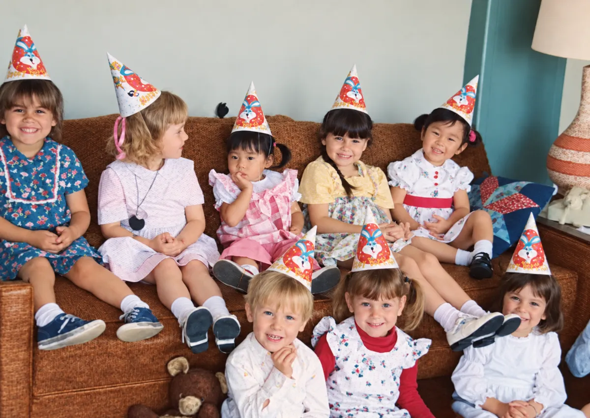 After: faded color snapshot of children in party hats sitting on a couch
