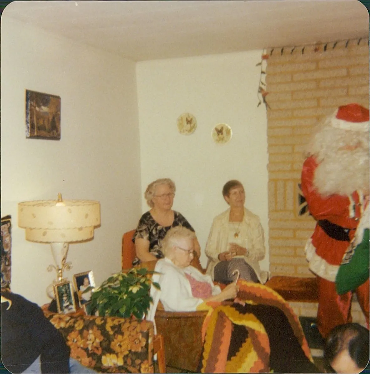 Before: faded color photo of family members in a living room with Santa Claus